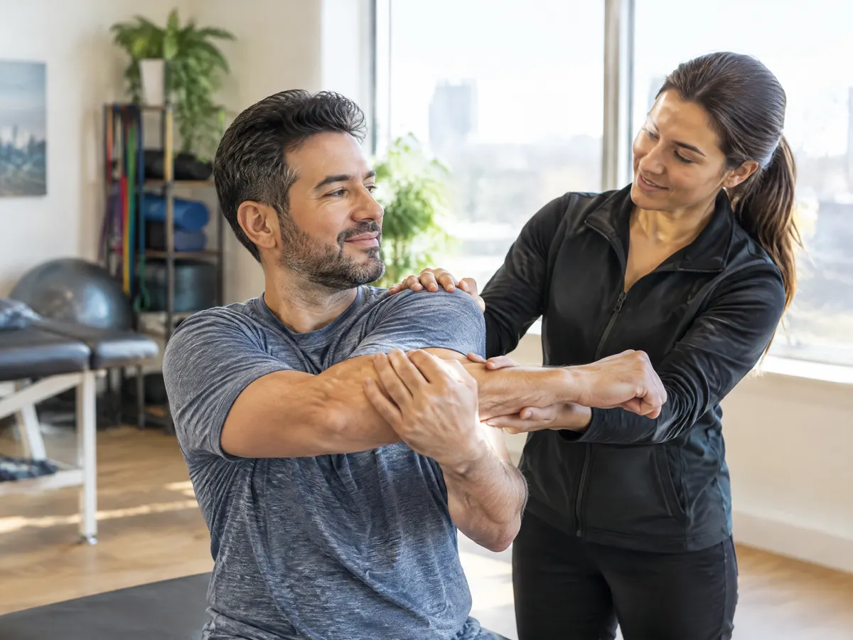A man doing a guided stretching session with a physiotherapist in a bright Vaughan clinic.