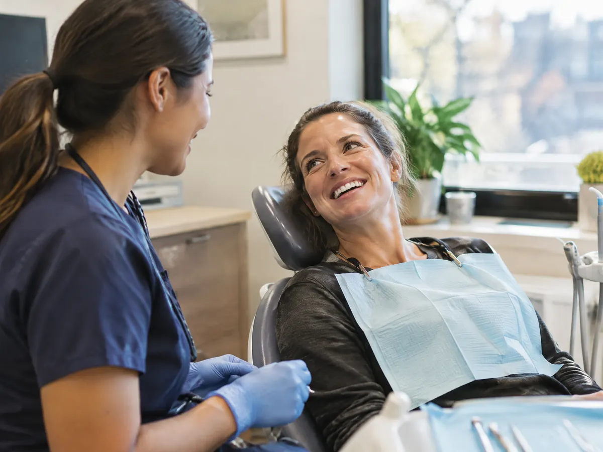 A self-employed contractor at the dentist chatting with the hygienist.